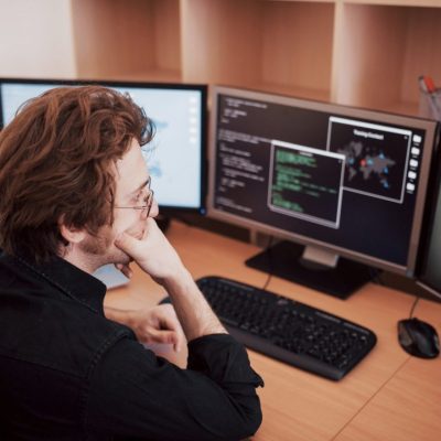 male-programmer-working-on-desktop-computer-with-many-monitors-at-office-in-software-develop-company.jpg